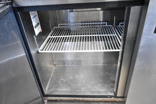 Bison MGF8402 stainless steel 2-door undercounter cooler, shown open. Features wire shelves, a label, and commercial casters. 115V, 1 phase.