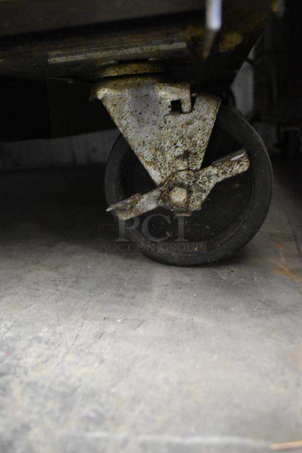 Close-up of rusted commercial caster wheel on a True TSSU-27-08 prep table, showing wear and condition.