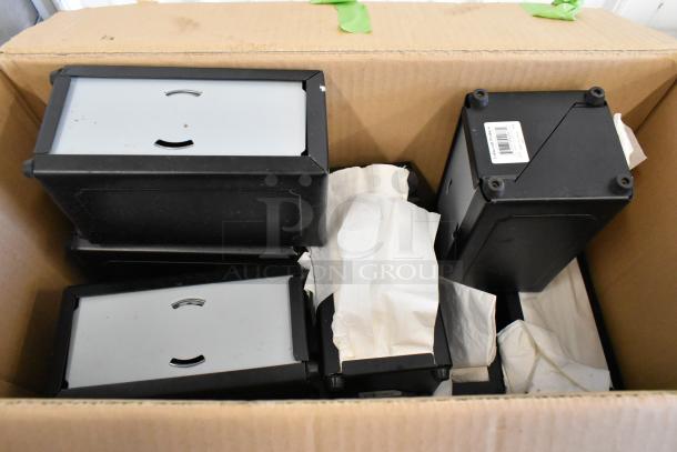 10 metal napkin dispensers in a cardboard box, black and silver, with visible napkins, slight wear, barcode label on one.