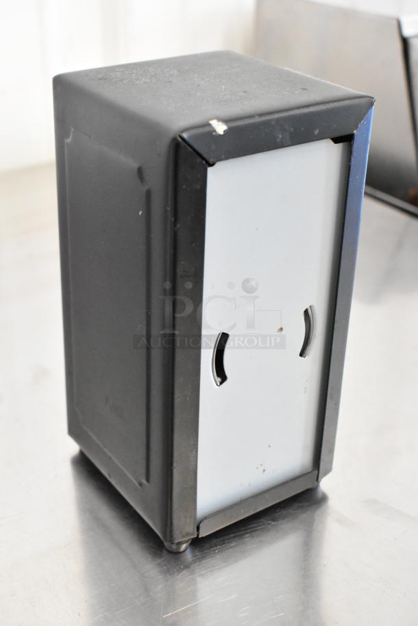 Metal napkin dispenser, black frame, visible wear, slot for napkin retrieval. Part of set of 10 for auction.