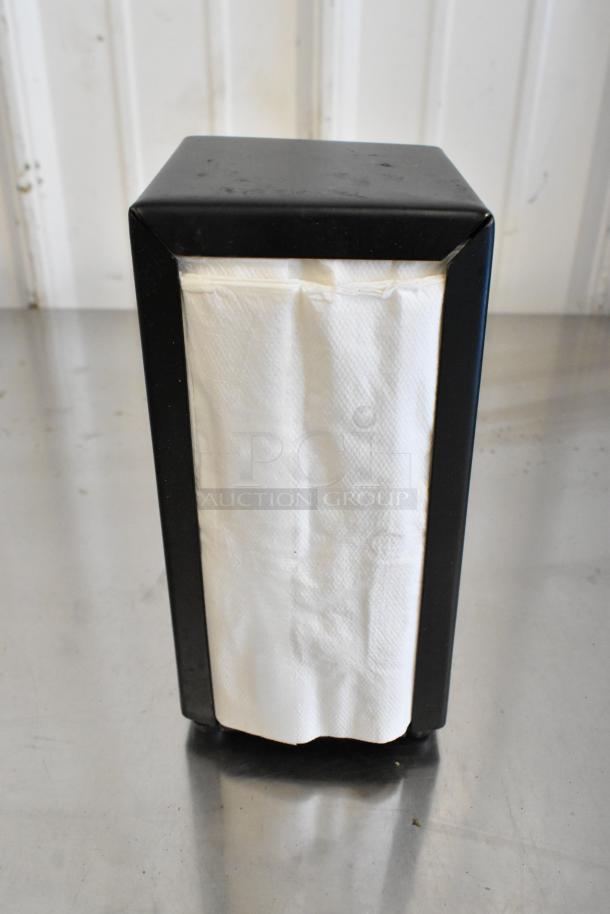 Black metal napkin dispenser, slightly worn, with white napkins. Simple design, ideal for commercial use. Auction lot: 10 units.