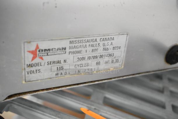 Omcan 300E stainless steel commercial meat slicer with blade sharpener, 115V, single-phase, made in Italy, label shown.