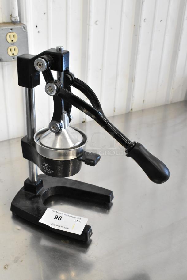 Metal manual citrus juicer with a sturdy black handle and funnel, branded "Lulay Kitchen," in good condition. Auction label present.