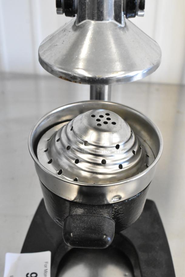 Metal manual citrus juicer, silver finish, sturdy construction, minor wear visible, suitable for home or commercial use.