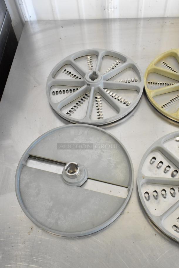10 various food processor blades in metal and plastic, showing different slicing and grating styles. Good condition.