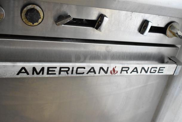 American Range stainless steel commercial 6-burner range with oven, salamander cheese melter, and back splash. Good condition.