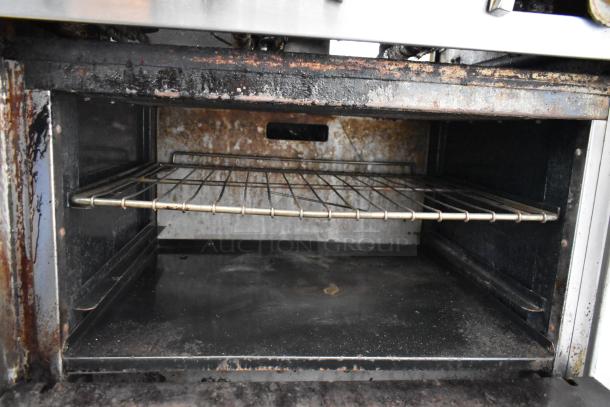 American Range commercial gas oven interior showing stainless steel rack, signs of wear, suitable for kitchens.
