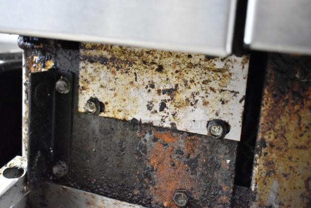 Rusted section of an American Range stainless steel commercial gas-powered 6 burner range. Signs of heavy use and wear.