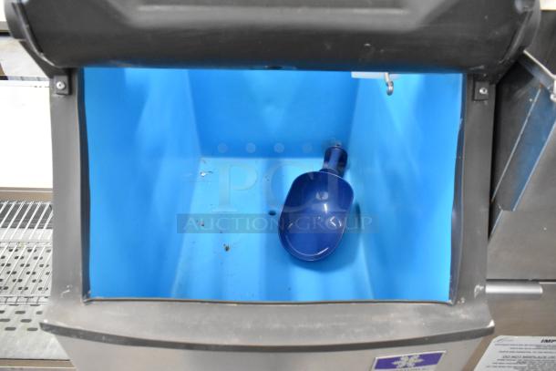Manitowoc D320 stainless steel commercial ice bin, open view, blue interior, scoop inside, clean condition.