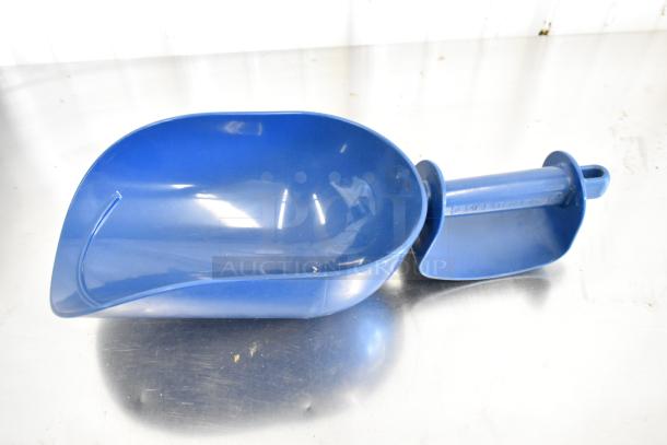Blue Manitowoc ice scoop on a reflective surface, labeled with "Manitowoc" branding, in good condition.
