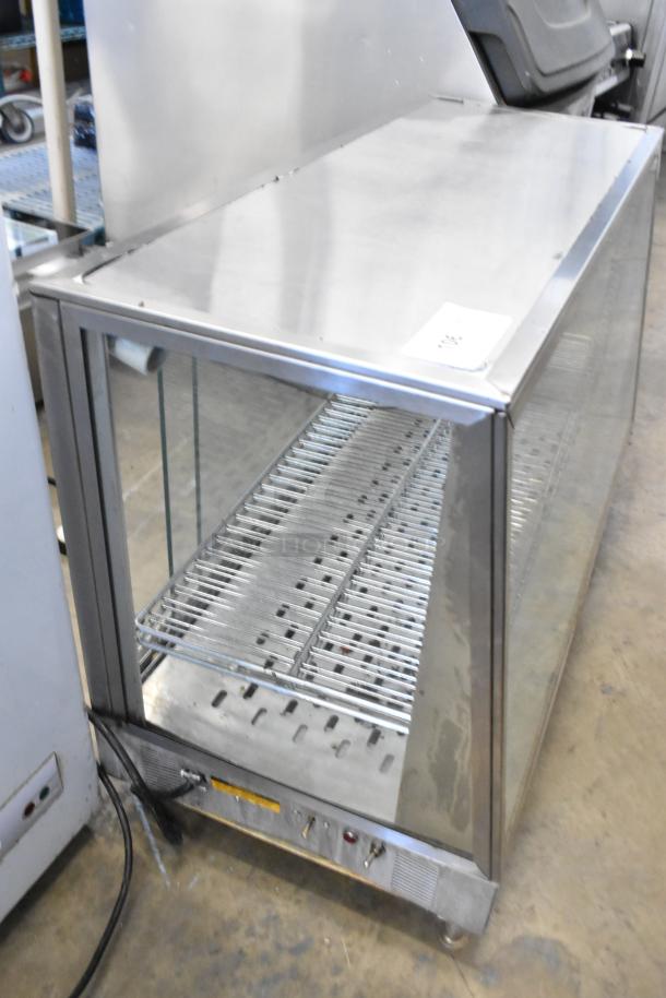 Metal countertop display case merchandiser, glass panels, adjustable shelves, used condition, power cable attached.