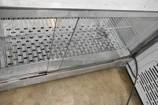 Metal countertop display case merchandiser with glass sliding doors and wire shelves, in fair condition, suitable for retail use.