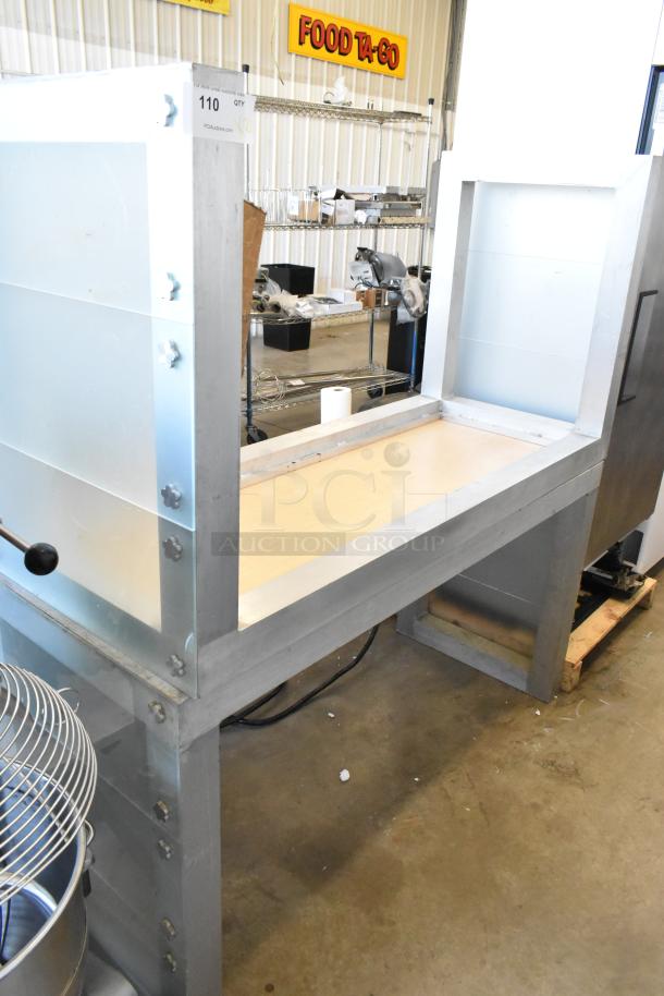 Industrial metal table with steel frame and wood surface, sturdy design. Tag reads "110 QTY 2," indicating quantity discount.