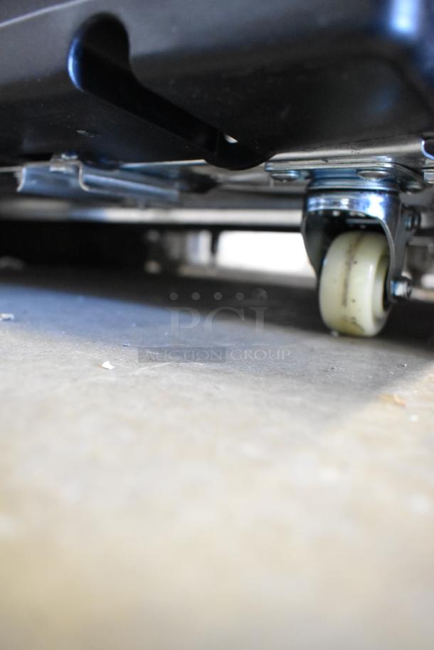 Close-up of the caster wheel on a KoolMore KM-MDR-1D-6C single door cooler, showing metal frame and commercial caster.