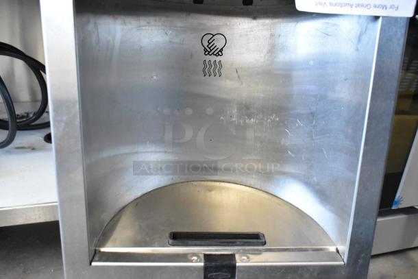 Bobrick Stainless Steel Hand Dryer in used condition, featuring a curved interior design and hand drying icon.