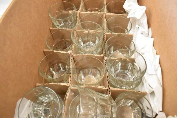Box containing twelve clear glass tumblers in excellent condition, each secured in cardboard dividers.