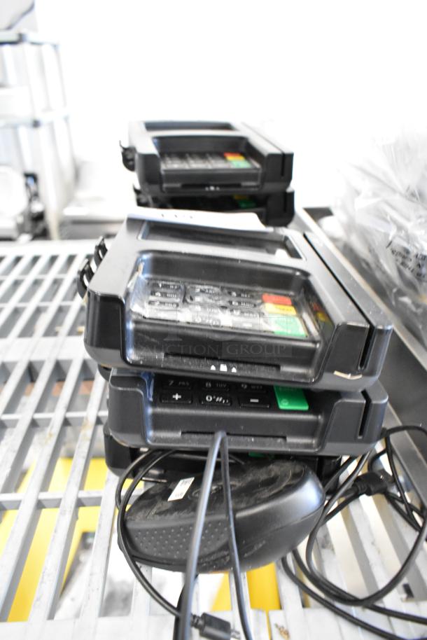 Stack of Ingenico iSC Touch 250 credit card readers with computer mouse, used, visible wear. Includes cords, no labels shown.