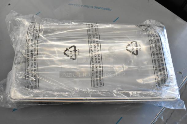 Stainless steel drop-in bin wrapped in clear plastic packaging with recycling symbols. New condition.
