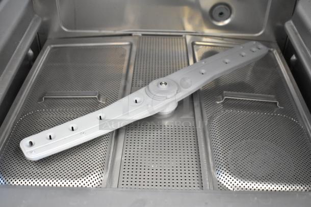 Brand new Noble 495HTUC24 undercounter dishwasher interior, stainless steel, high-temp, with spray arm visible.