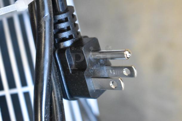 Power plug of KoolMore KM-MDR-1GD-10C commercial cooler, showing three-prong design and part of attached cord.