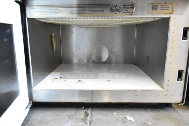 Amana HDC12A2 stainless steel commercial countertop microwave oven, showing interior with visible wear and service label.