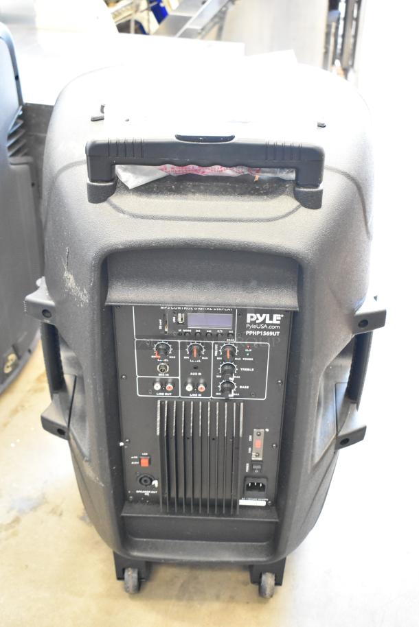 Pyle PPHP1569UT speaker, visible control panel with knobs and ports, good condition, rolling wheels for transport.