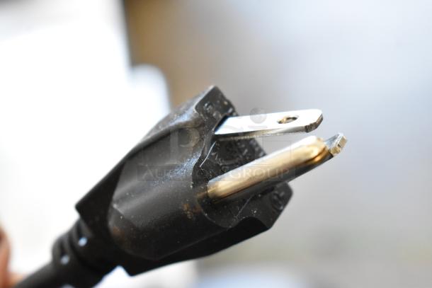 Close-up view of a black electrical plug with two metal prongs.