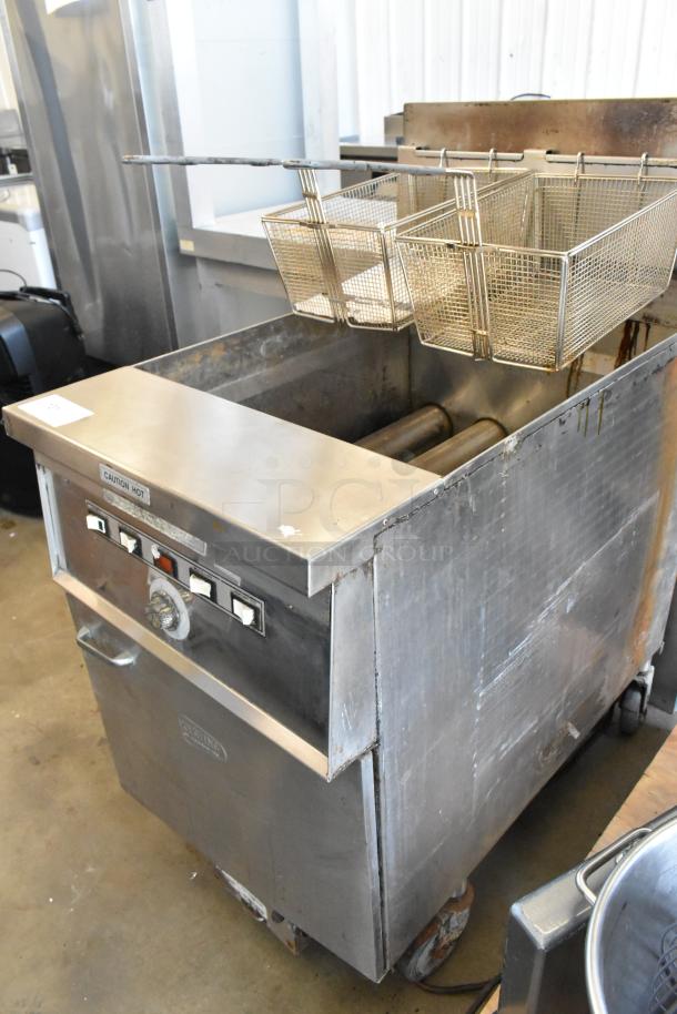 Keating stainless steel commercial gas fryer with 2 metal baskets, on casters. Slight wear, labeled "Caution Hot."