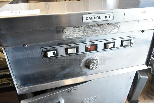 Keating stainless steel gas-powered deep fryer with two metal baskets, on commercial casters, features control panel with caution label.