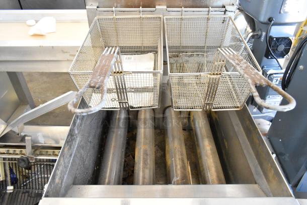 Keating stainless steel commercial gas fryer with two metal fry baskets on casters, showing used condition.