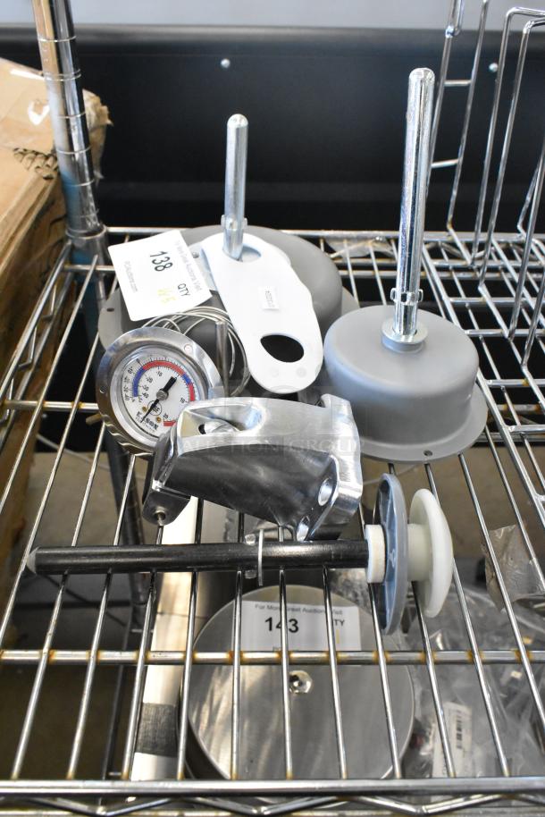 Five brand new scratch and dent items, including light fixtures and a thermostat, on a metal rack; tags with item numbers visible.