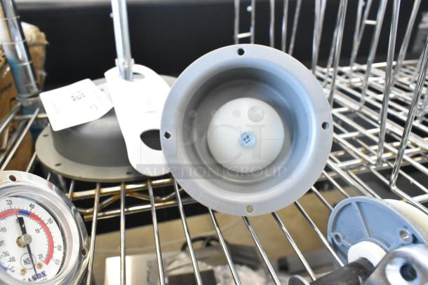 5 brand new scratch and dent items on metal rack, including light fixtures and a thermostat, label shows lot number.