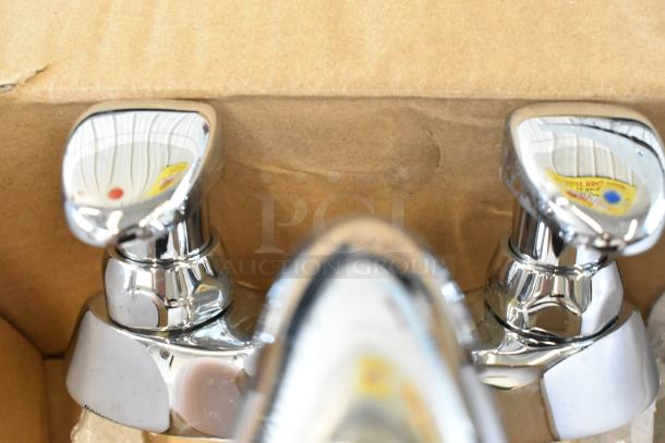 Brand new Delta faucet with visible scratches and dents in chrome finish, in original packaging.