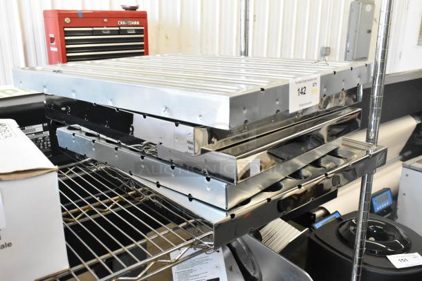 5 new metal grease hood filters with minor scratches and dents. Stack of five on a metal shelf. Auction tag visible.