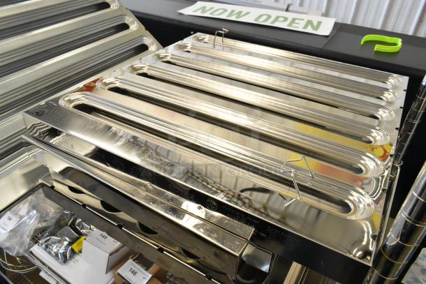 Five brand new metal grease hood filters, showing visible denting. Features polished finish and labeling.