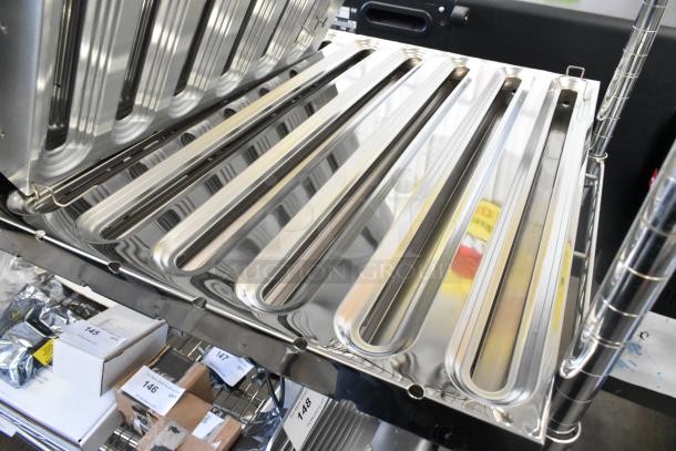 5 brand new scratch and dent metal grease hood filters displayed, showcasing reflective surfaces and various markings.