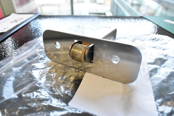 5 brand new scratch and dent items including a metal latch mechanism, displayed over packaging material.