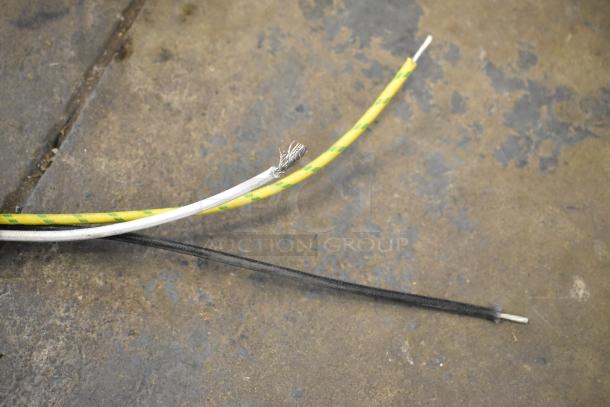 Cords with exposed ends and green-yellow insulation on a textured surface.