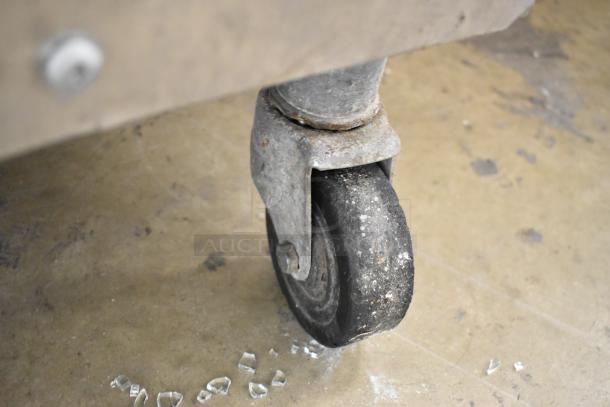 Close-up of a commercial caster on the Taylor 754-27 soft serve ice cream machine. Slight wear visible on the wheel.