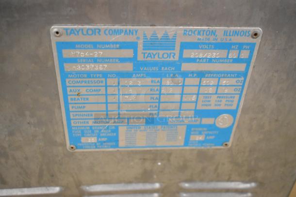 Taylor 754-27 stainless steel soft serve ice cream machine label. Shows model and specs: 208/230V, 1-phase.