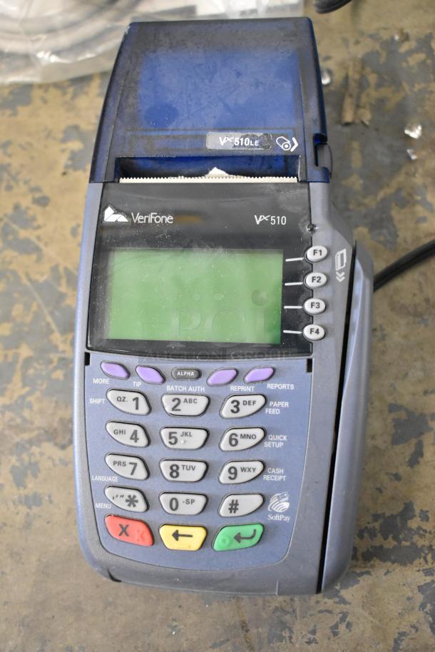 VeriFone VX 510LE credit card reader on a table, used condition, showing keypad and function buttons.