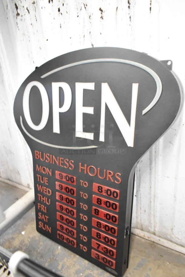 "Open" sign with business hours listed, black and red design, slightly worn condition, part of auction lot with various items.