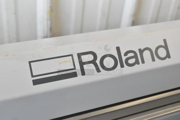 Roland Camm-1 Pro GX-300 Sign Maker with logo visible. White casing shows minor wear. Voltage: 100-240V, 1 Phase.