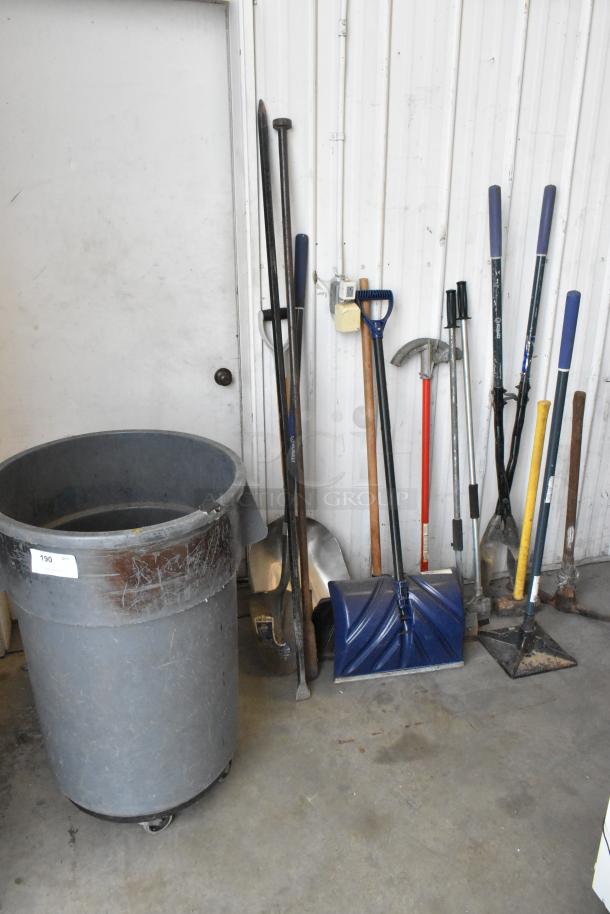 Lot of various tools including snow shovel, tamper, pole digger, and trash can. Used condition with visible wear.
