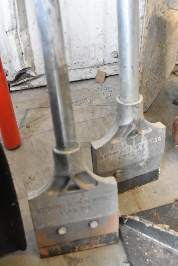 Lot of tools including a snow shovel, tamper, and pole digger in used condition. Metal heads show wear; utilitarian value.