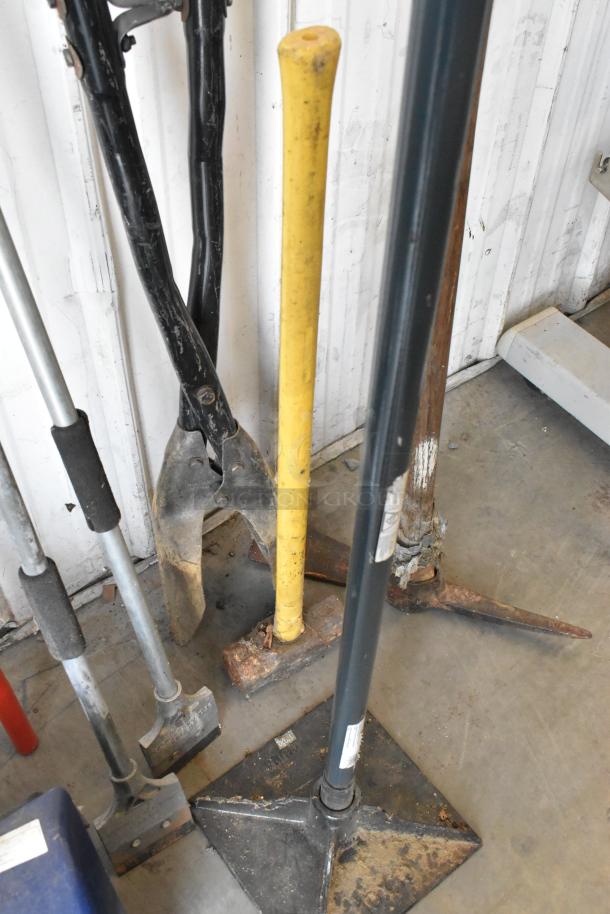 Lot of tools including yellow-handled tamper, snow shovel, pole digger, and trash can; mixed condition.