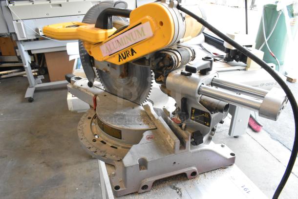 DeWalt DW718 miter saw, 15 amp, corded, single bevel, showing wear. Marked for aluminum cutting. 120 volts, 1 phase.