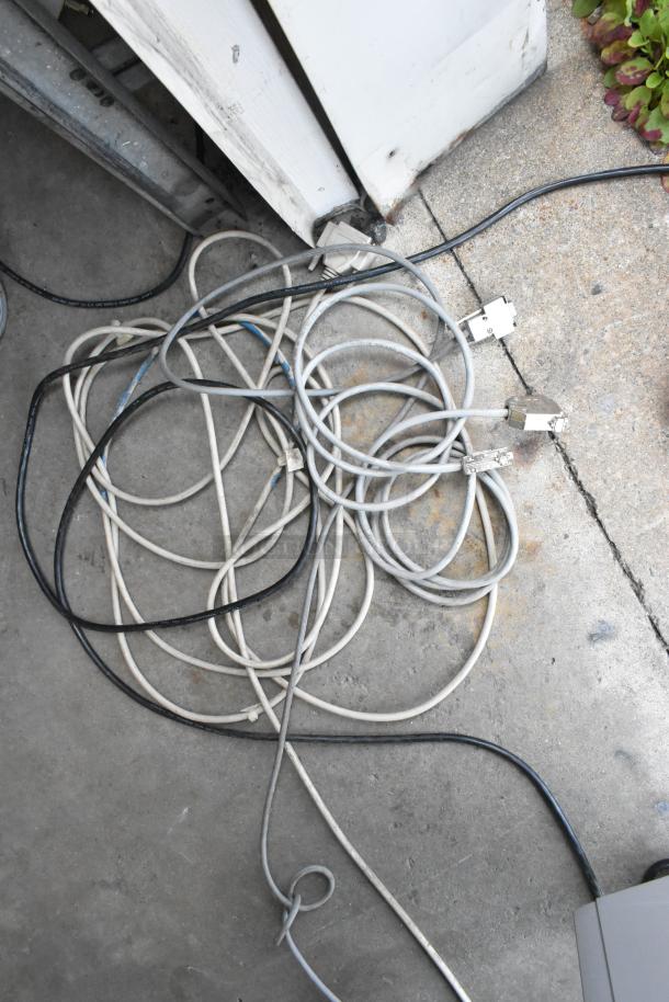 Tangled cables on concrete floor, likely part of Mimaki CF-0912-2 Flatbed Cutter setup, showing varied connectors.