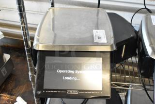 Hobart digital scale with touchscreen displaying "Operating System Loading," metal platform, auction tag labeled "101."