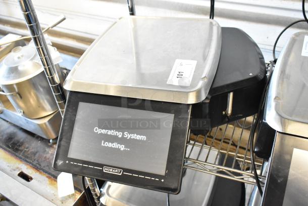 Hobart scale with touchscreen showing "Operating System Loading," model 101 label, stainless steel platform, good condition.